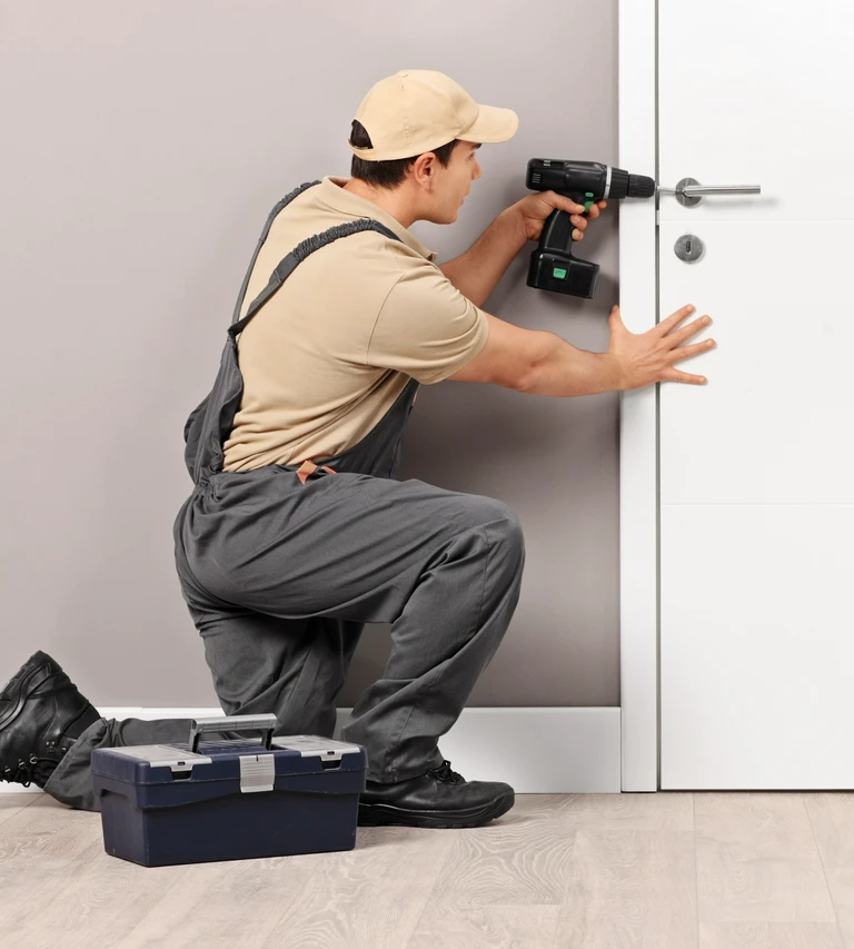 fachowiec instalujący klamkę za pomocą wkrętarki